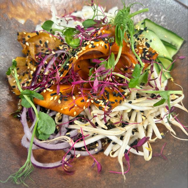 A poke bowl with cucumber, wild rice, pickled mooli, cabbage and sesame seeds